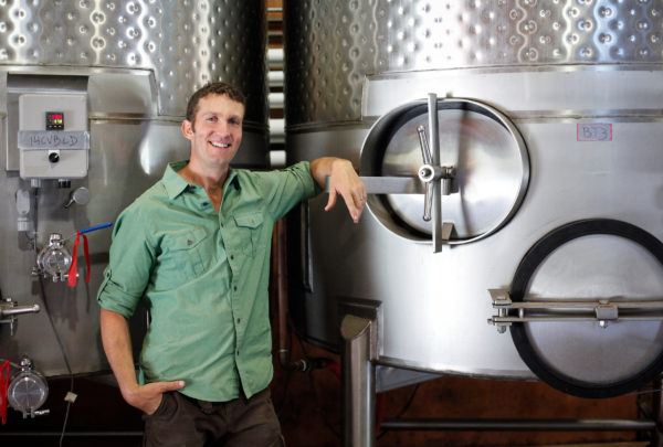 Jim Duane standing in front of fermentation tanks